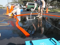USGS researchers spray water on lots sealed with coal-tar based sealcoat