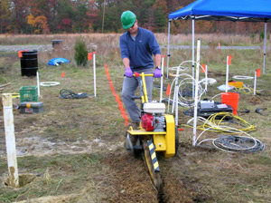  [Photo: USGS scientist operating equipment to dig shallow trench.] 