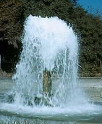 [Photo: Ground water flowing out of well.]