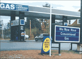 Photograph showing a gas station with a sign that says "We now have conventional gas" to show there are areas where reformulated gasoline is no longer required.