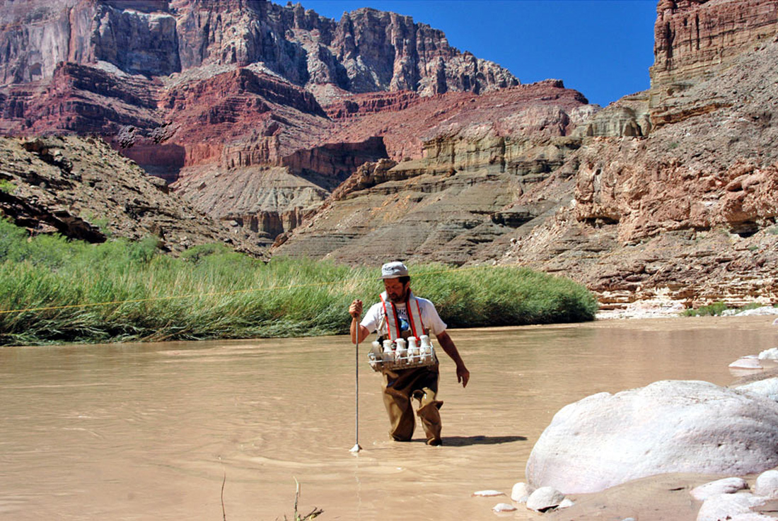 A USGS hydrographer collecting a suspended-sediment water sample from the Little Colorado River, a kilometer upstream from the Colorado River, Grand Canyon, Arizona, USA