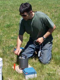 [Photo: Scientists adjusts seismic geophysical equipment.] 