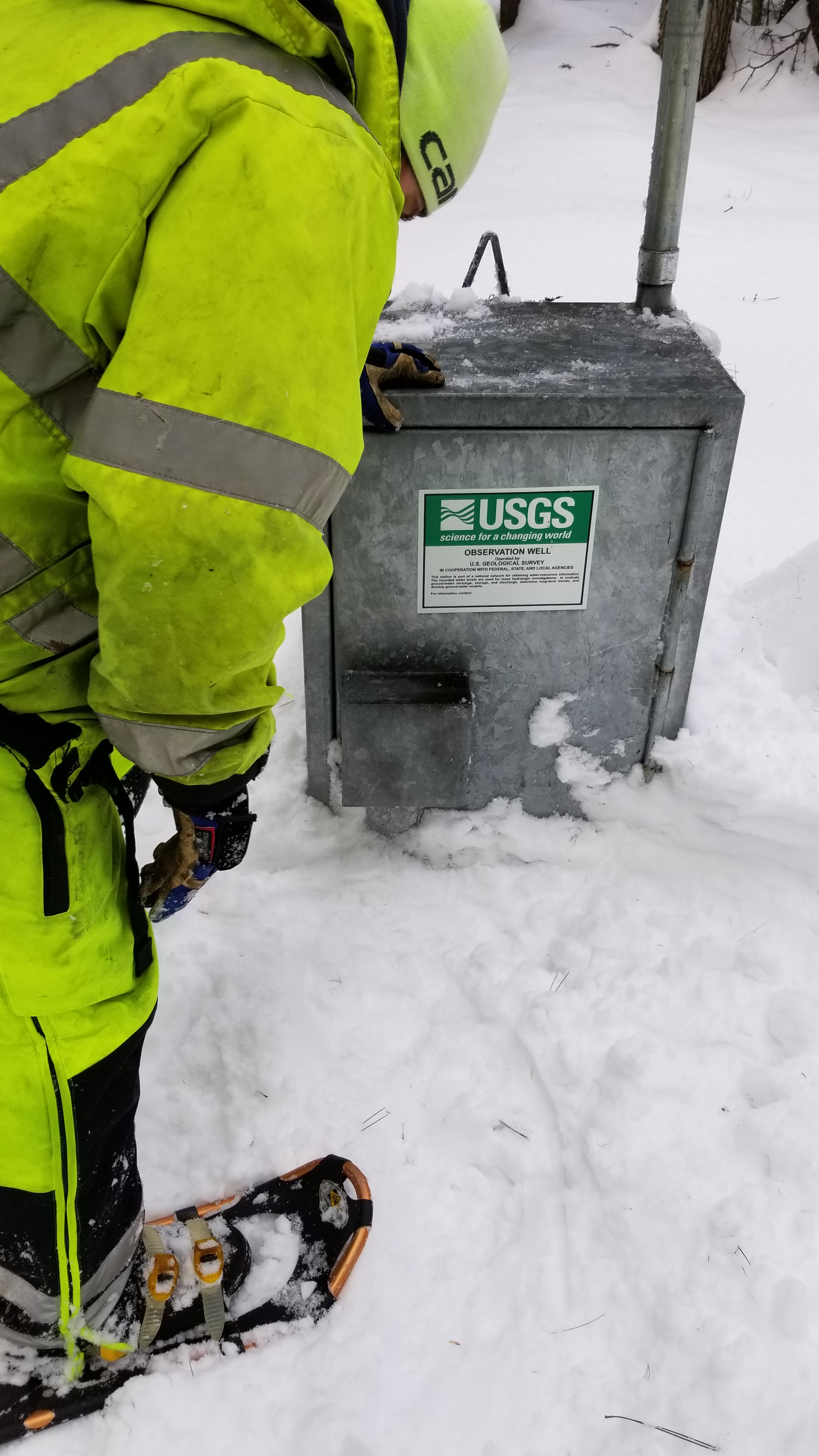  [ Photo of scientist opening well housing in snow. ]