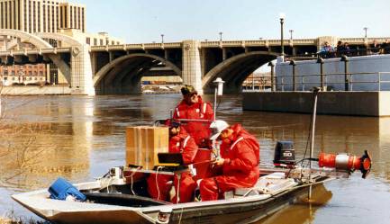 Photo of USGS bridge scour data collection team with equipment and boat