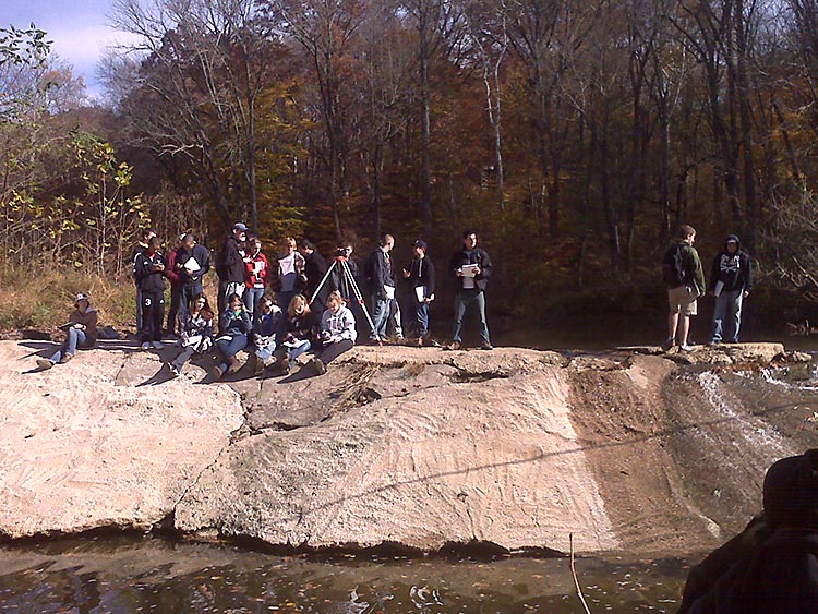 A University of Delaware student research field crew, supported by the Delaware Water Resources Center, conducts a survey along a stream bed.